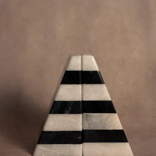 Load image into Gallery viewer, Striped Black &amp; White Marble Bookends, set of hand-shaped, assembled, and polished marble triangular wedge-shaped bookends with dark black and white horizontal striped bands, displayed together to form a symmetrical triangle shape on a beige surface and against a coordinating beige background. 