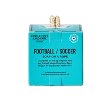 Load image into Gallery viewer, Football Ball Soap On A Rope, square turquoise Football/ Soccer Soap On A Rope packaging box with black lettering, mandarin spice scent soccer ball scent graphic, and cream rope extending from the top of the box against a white background.