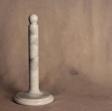 Load image into Gallery viewer, Marble Paper Towel Holder, hand-carved and polished white marble paper towel holder with subtle gray veining, a round flat base, and a rounded ball finial, displayed on a beige surface and against a coordinating beige background.  