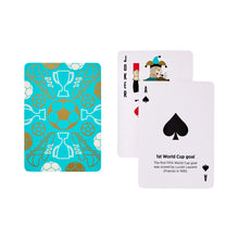 Load image into Gallery viewer, Football Themed Playing Cards, turquoise playing cards with gold and white soccer ball, trophy, and cleat illustrations displayed beside a joker referee card and ace of spades card with World Cup trivia against a white background. 