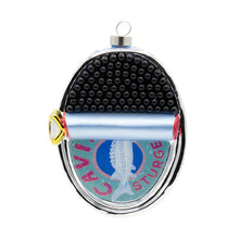 Load image into Gallery viewer, Caviar Ornament, glass ornament shaped like an opened oval tin of caviar with tightly packed rows of raised, glossy black caviar pearls, a partially rolled-back silver-blue lid featuring a sturgeon illustration and "CAVIAR STURGEON" red lettering, a gold pull tab, and a silver-tone cap, against a white background. 