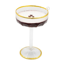 Load image into Gallery viewer, Espresso Martini Ornament, clear coupe ornament with gold rim and matching gold-trimmed base, layered dark brown espresso and white foam topped with three brown coffee beans, scalloped lower bowl, clear stem, and white hanging loop, against a white background. 