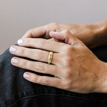 Load image into Gallery viewer, Gold Ridged Rings, 18K gold-plated ring with evenly spaced vertical etched ridges, shown on a model's hand resting on knee covered in dark denim against a cream background. 