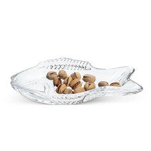 Load image into Gallery viewer, Swimming Fish Dish, clear fish-shaped glass dish with raised scale and fin detailing, displayed holding pistachios, against a white background. 