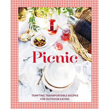 Load image into Gallery viewer, Picnic Cookbook, cookbook cover featuring the title "Picnic" in red lettering over a picnic scene with a wicker basket holding a dark thermos, with glasses and a bottle of pink beverage, a bowl of green olives, slice of rustic bread, stacked white plates, and silverware on a white picnic blanket, framed by a red-and-white gingham border, displayed against a white background. 