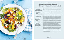 Load image into Gallery viewer, Picnic Cookbook, open cookbook displaying a recipe page alongside a photo of a baby spinach salad with roasted butternut squash, beetroot, crumbled goat cheese, herbs, and sliced almonds in a white bowl with a blue rim, with a blue and white checkered napkin on a weathered light blue tabletop. 