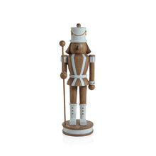 Load image into Gallery viewer, Brown nutcracker figurine holding a pole with a matte finish and white painted details including hat, boots, belt, and cuffs.White parallel stripes in the middle.  Standing on a brown base with a white center. Displayed against a white background.