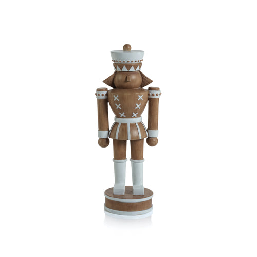 Brown nutcracker figurine with a matte finish and white details, including a round hat, collar, belt, cuffs, and boots with geometric accents. Standing on a brown round base with white stripes. Displayed against a white background. 