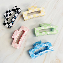 Load image into Gallery viewer, Checker Lovers Hair Claw | 5 Styles, five rectangular hair claw clips with open cutout centers, featuring white checkerboard patterns paired with black, yellow, pale pink, pale green, and blue, displayed on a white marble surface. 