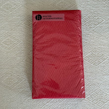 Load image into Gallery viewer, Red Herringbone Textured Guest Towel, overhead view of rectangular red paper guest towels with a subtle herringbone texture, wrapped in clear packaging with a rectangular white Boston International label in the upper-left corner, resting on cream fabric with a woven geometric pattern.