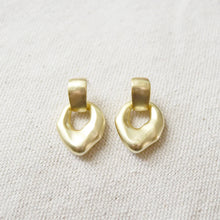 Load image into Gallery viewer, Pair of 14K gold semi-matte gold plated brass casting dangle earrings on a cream woven fabric background.