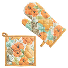 Load image into Gallery viewer, Set of quilted oven mitt and pot holder with pumpkin design on a white background. Set has orange colored loops for hanging. Design includes orange pumpkins, gourds, green leaves, white berries, and brown pinecones . Bordered in orange. 