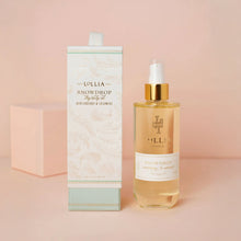 Load image into Gallery viewer, Lollia Snowdrop dry body oil displayed beside its patterned white and mint box on a soft pink background. 